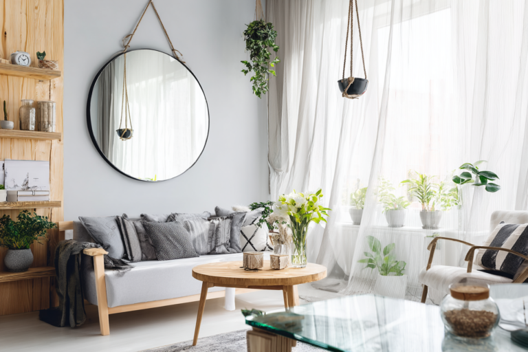 Sala de estar clara com espelho grande e decoração minimalista para ampliar ambientes pequenos